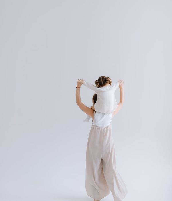 Woman in a serene yoga pose in a room with soft natural light.