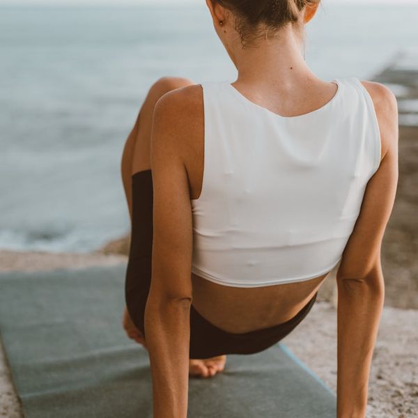 Woman practicing a dynamic yoga pose outdoors during sunrise.